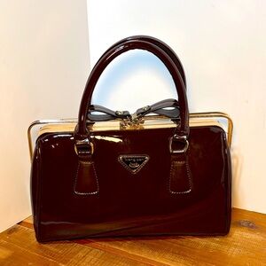 Weng Pan patent leather frame satchel in a burgundy color.